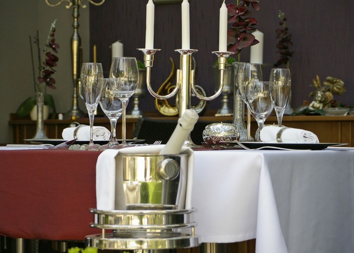 Megterített asztal a télikertben ezüst gyertyatartóval és dekorációval