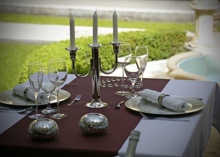 Megterített asztal a télikertben ezüst gyertyatartóval és dekorációval