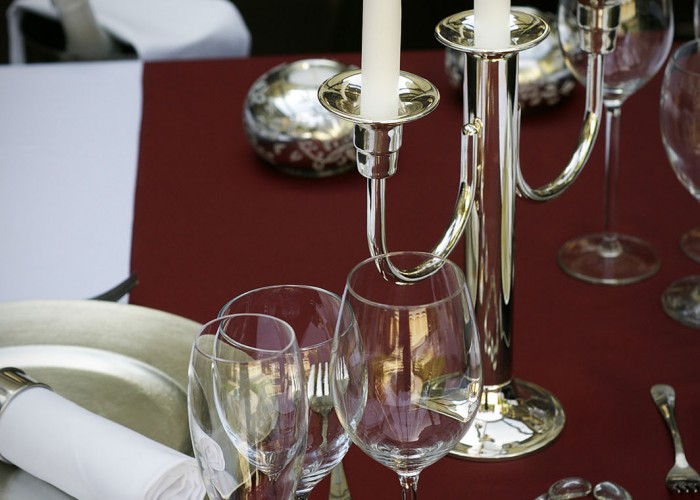 Megterített asztal a télikertben ezüst gyertyatartóval és dekorációval