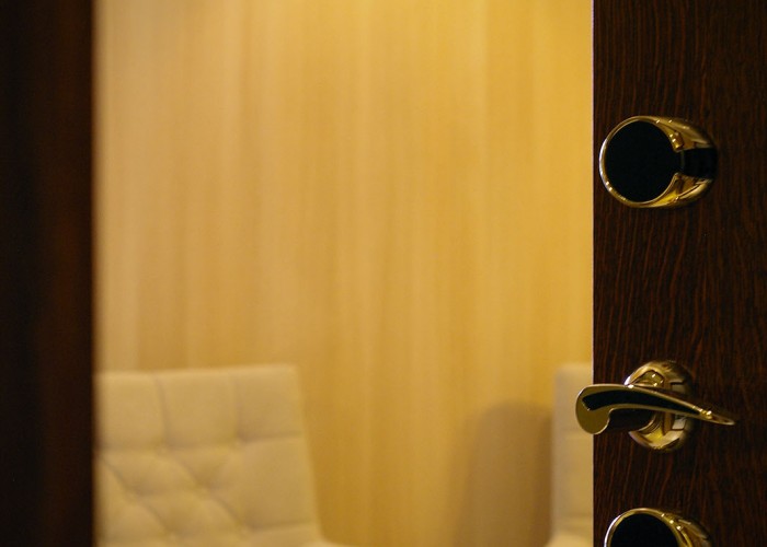 Családi lakosztály - érintőkártyás aranyozott bejárati ajtó, háttérben a bútorzat