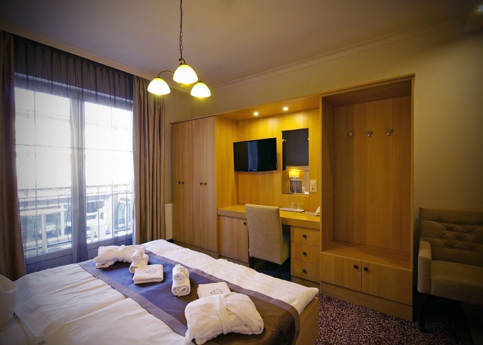 Családi szobáink beltere, LCD TV, tárolók, ágy és erkély - Xavin Hotel Harkány