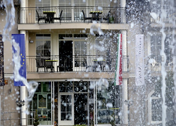 A szálloda főbejárata, valamint az emeleti erkélyek a szökőkút vizén át szemlélve, Xavin Hotel Harkány