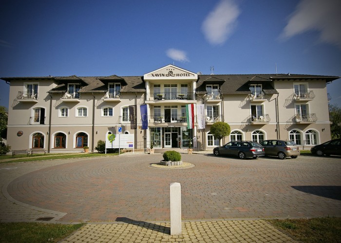 A szálloda főbejárata valamint homlokzata és a parkoló autók.