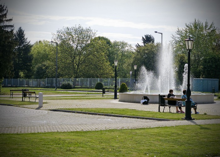 A szálloda előtti park szökőkútja, valamint a megpihenő vendégek.