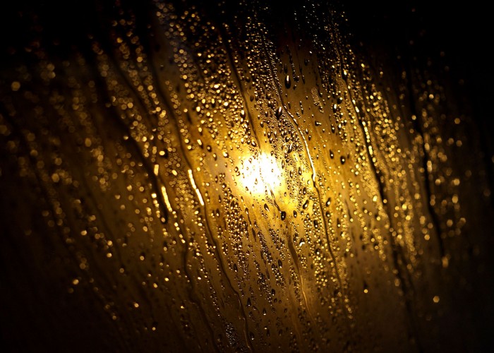 Megcsillanő vízcseppek és pára a szálloda gőzkabinjának üvegajtaján.