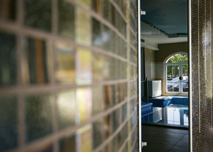 A szálloda sókabinjának ajtaja, háttérben a visszatükröződő merülő medence képe.