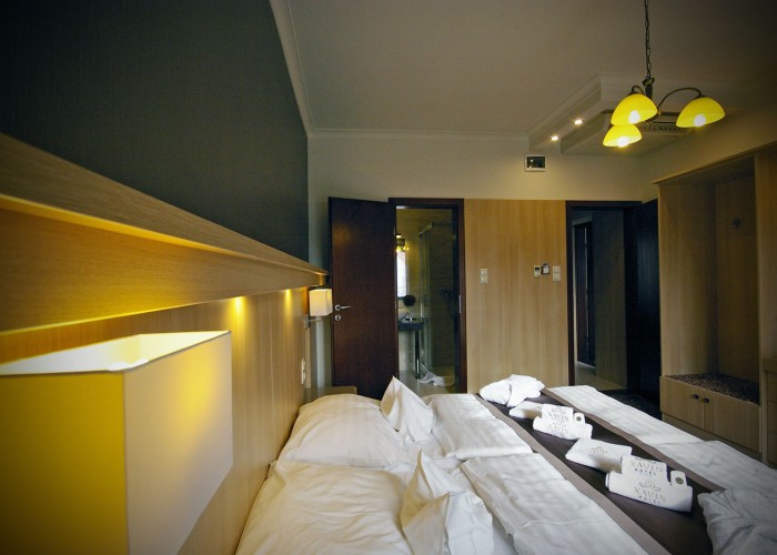 A családi szobák egyik oldala, jobb oldalt a háttérben az átjáróval a másik helyiségbe, Xavin Hotel Harkány