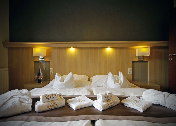 A családi szobáink egyeik felének ágyam rajta a törölközőkkel várja a vendégeket, Xavin Hotel Harkány