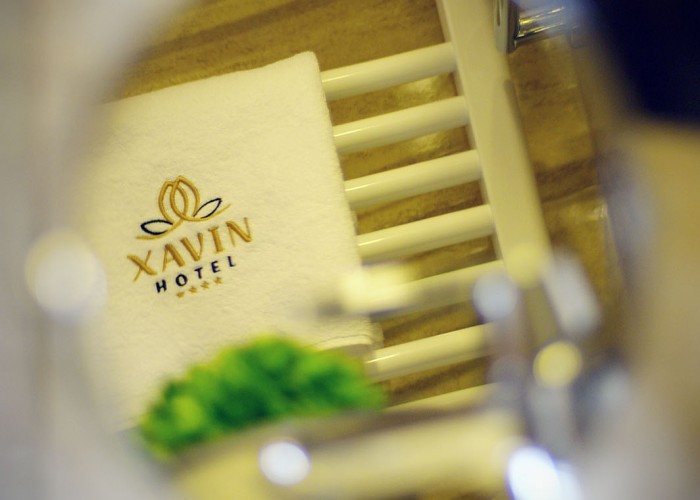 A fürdőszabi radiátoron elhelyezett, hímzett törölköző Xavin felirattal