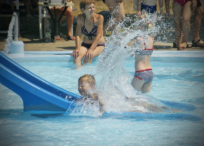 Strand, szivárványcsúszdán lecsúszó gyermek