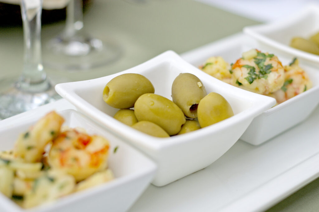 Zöld olivabogyó, fokhagymás garnéla a terítéken - Xavin Hotel Harkány télikert